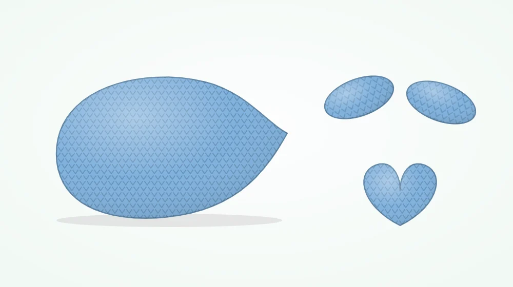 Blue crocheted whale pieces laid out: a rounded body tapering to a narrow end, two small side fins and a two-lobed tail fluke
