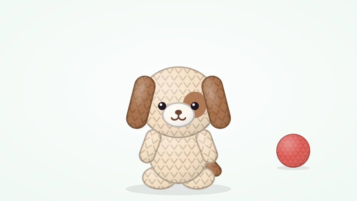 Seated crocheted puppy in cream with long floppy brown ears, a brown patch around one eye, an oval muzzle and a small tail