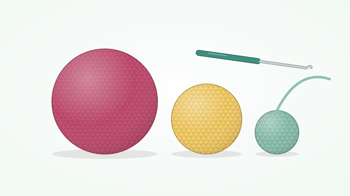 Three crocheted balls in different sizes and colors with a crochet hook and a strand of yarn